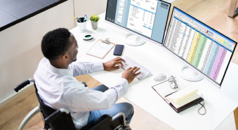 A Normandale student types in a cubicle.