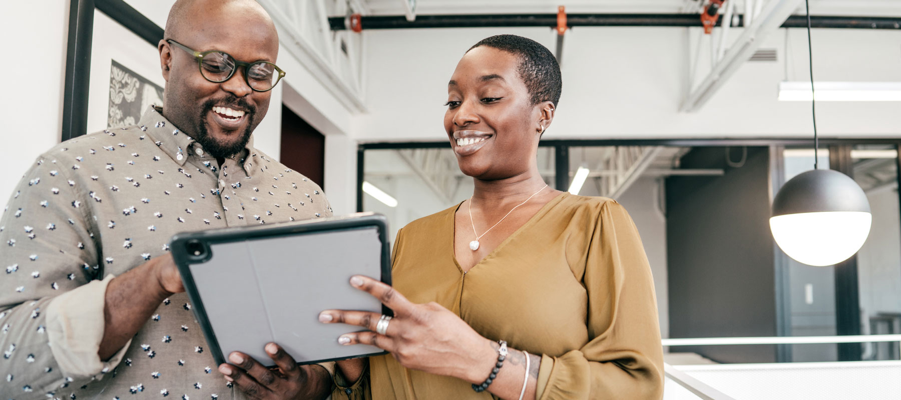 Man and woman smiling over iPad