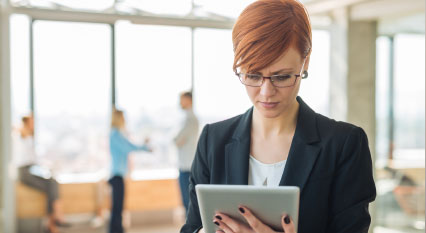 A lady works on a tablet device.