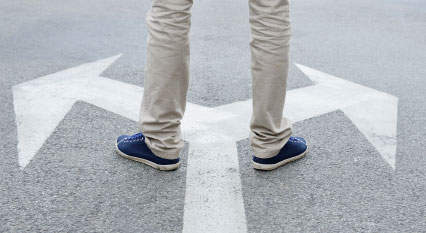 man in khakis standing on sidewalk with arrows