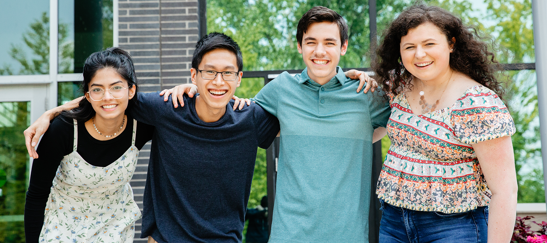 Four students stand together, smiling.