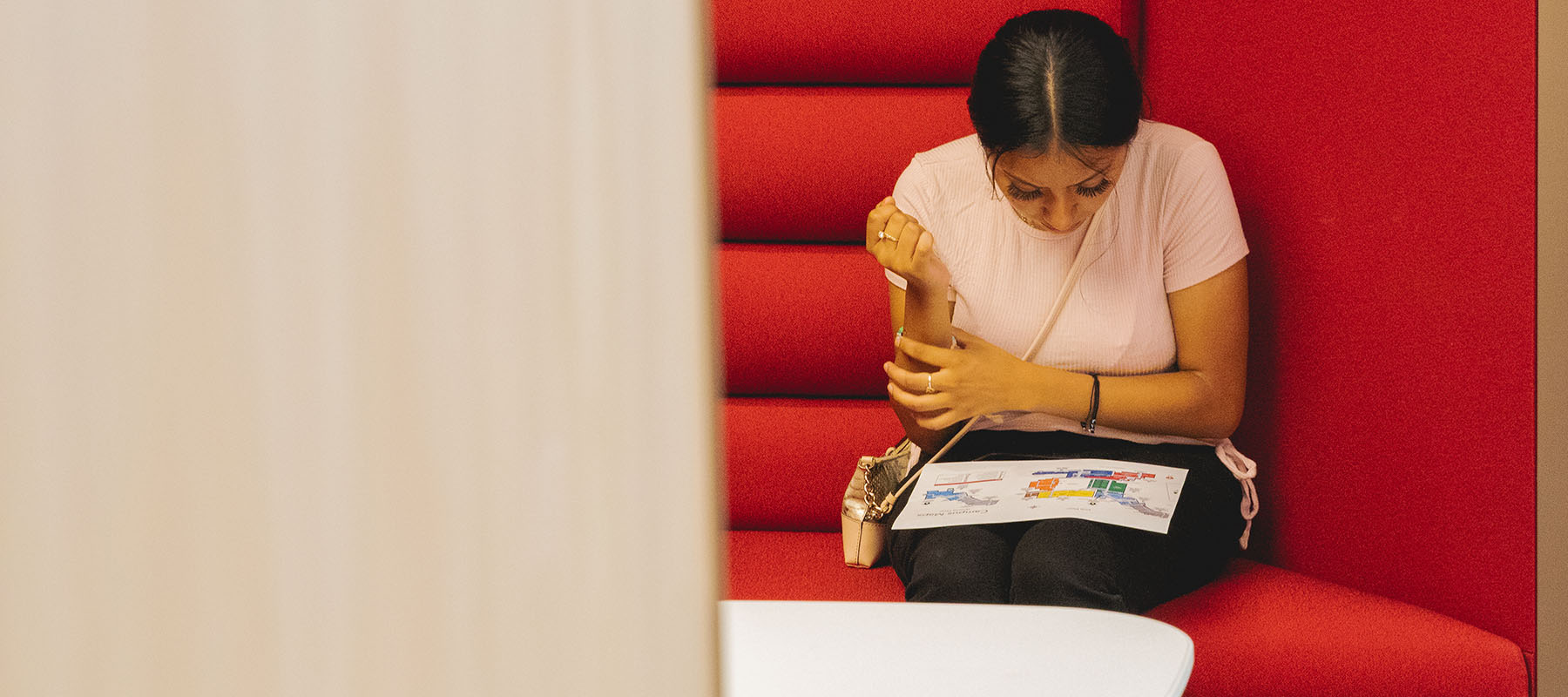 A student studies a paper on her lap.