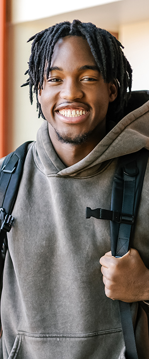 A Normandale student in a yellow headscarf smiles.