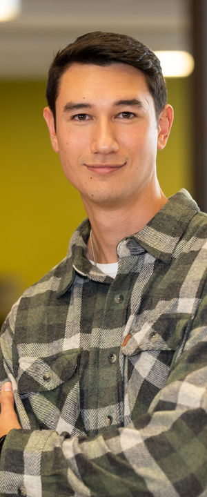 A Normandale student in a yellow sweater smiles.